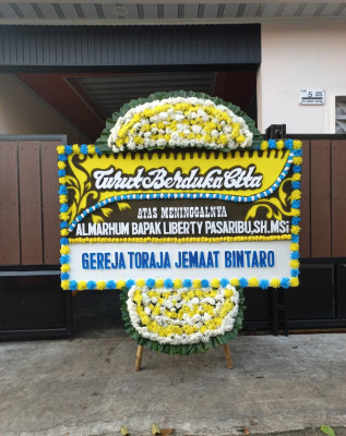 Papan Bunga Duka di Bahu