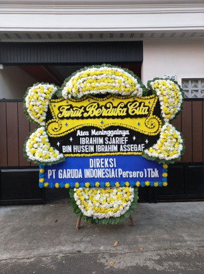Papan Bunga Duka di Bahu